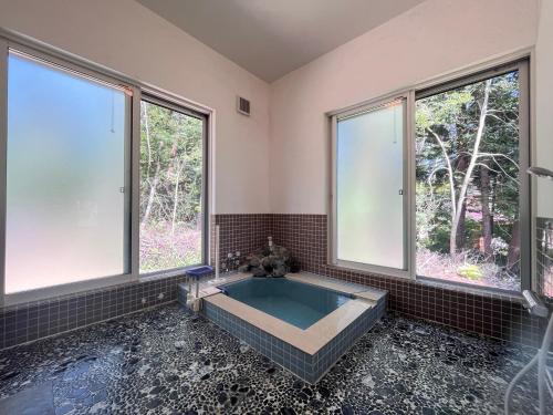 a large bathroom with a tub with windows at リゾートハウス正波2 in Azumino