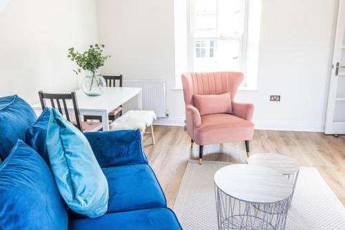a living room with a blue couch and a table at The Lookout in Alnwick