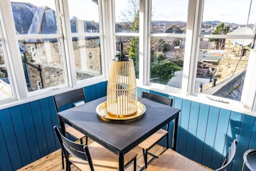 a black table and chairs in a room with windows at The Lookout in Alnwick
