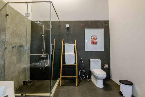 a bathroom with a toilet and a glass shower at Bedrock Beach Villas in Kalpitiya