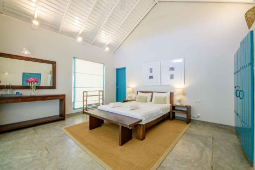 a bedroom with a bed and a table and a mirror at Bedrock Beach Villas in Kalpitiya