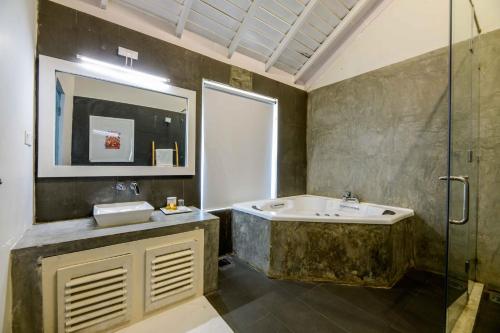 a bathroom with a sink and a glass shower at Bedrock Beach Villas in Kalpitiya