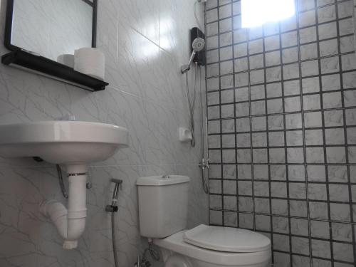 a bathroom with a toilet and a sink at Pacifico Seaside Lodge in Moalboal