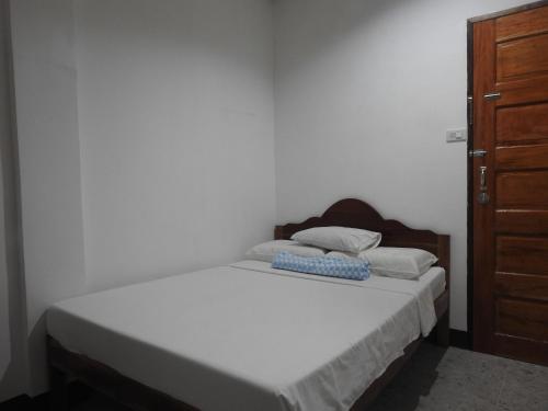 a bedroom with a bed and a wooden cabinet at Pacifico Seaside Lodge in Moalboal