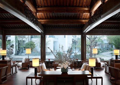 a lobby with a table and chairs and a large window at 上海松江广富林宰相府酒店 in Songjiang