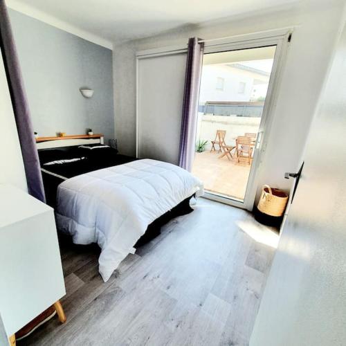 une chambre avec un lit et une porte coulissante en verre dans l'établissement 2 terrasses JolieT2 clim, parking privé, à Canet