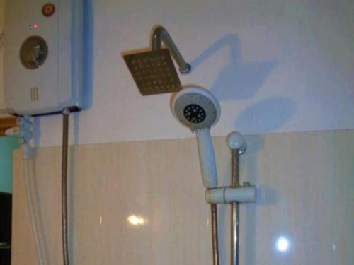 a shower head on a wall in a bathroom at Green Valley Home stay in Talpe