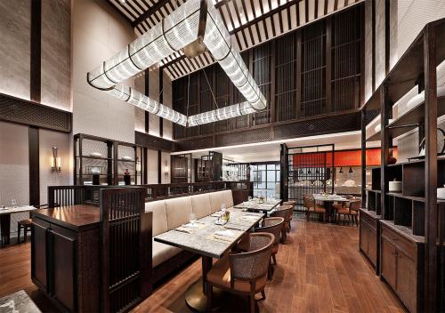 a restaurant with tables and chairs in a room at 上海松江广富林宰相府酒店 in Songjiang