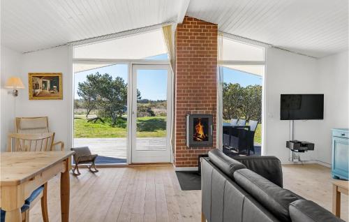 a living room with a fireplace and a table at Holiday Home Øster Kjulvej in Hirtshals