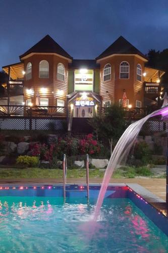 a fountain in a pool in front of a house at Gyeongju Princess in Gyeongju
