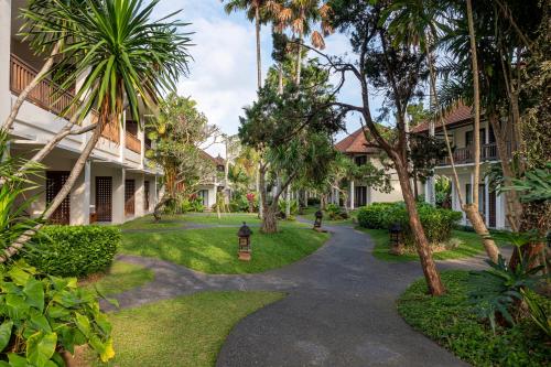 a walkway through the courtyard of a resort with palm trees at Pertiwi Resort & Spa in Ubud
