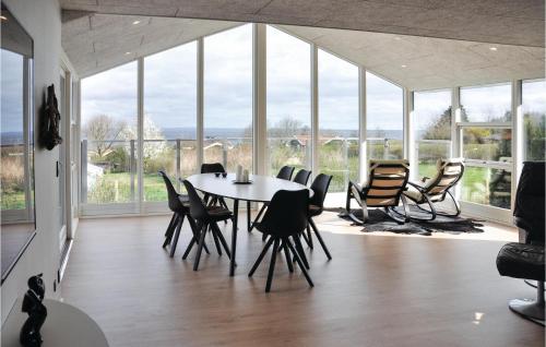 a dining room with a table and chairs and windows at Holiday Home Kildevangsvej Asperup Ii in Asperup