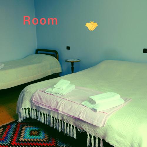 a room with two beds with towels on them at Kroi'Pistolve in Krujë