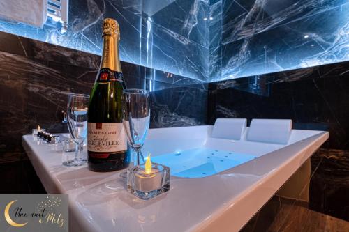 a bottle of champagne and a candle on a table at Sweet Spa au coeur de Metz in Metz