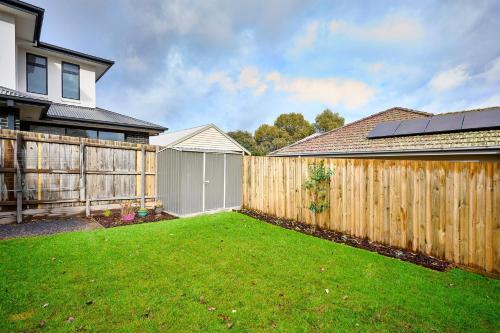 a wooden fence in a yard next to a house at 4 Bedroom Home in Heathmont Perfect for Families in Heathmont