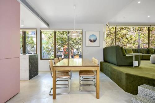 a dining room with a table and a green couch at Bourke Street Urban Retreat in Melbourne