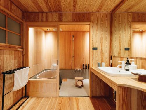 a bathroom with a tub and a sink and a shower at RITA Yame Fukushima in Yame