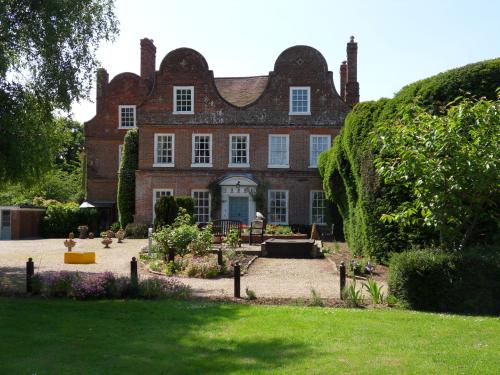 a large brick building with a clock on the front of it at Mangreen Country House in Norwich