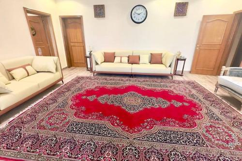 a living room with two couches and a red rug at 4Bedrooms Luxurious Furnished plus Big Majlis in Sharjah
