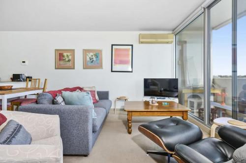 a living room with two couches and a tv at The Gallop Kensington in Melbourne