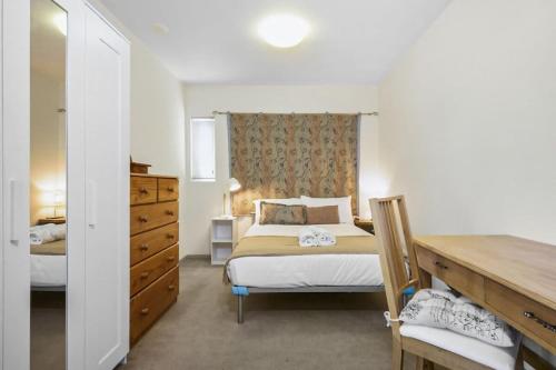 a bedroom with a bed and a dresser at The Gallop Kensington in Melbourne