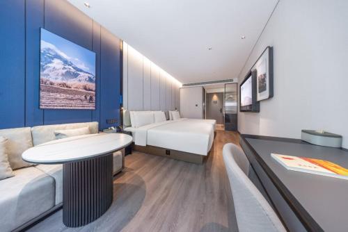 a hotel room with a bed and a couch at Atour Hotel Beijing Chaoyang High Speed Railway Station in Beijing