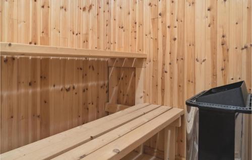 a wooden cabin with a bench and a trash can at Nice Apartment In Dannemare With Sauna in Dannemare