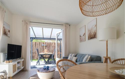 a living room with a table and a couch and a television at Cozy Home In Heinkenszand With Kitchen in Graszode