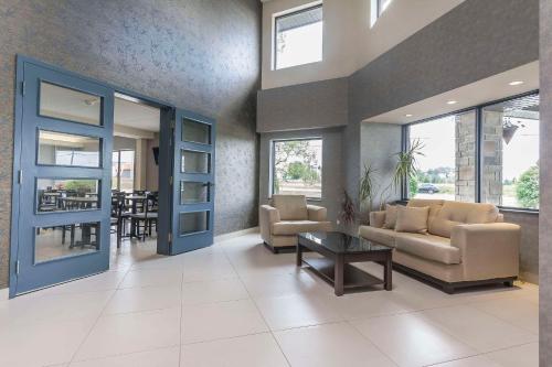 a living room with a couch and chairs and a table at Comfort Inn in Lévis