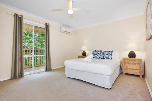 a white bedroom with a bed and a window at Spacious 3BR Family Haven in Upper Ferntree Gully in Fern Tree Gully