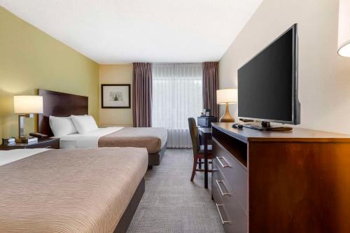 a hotel room with two beds and a flat screen tv at Quality Inn in Peterborough
