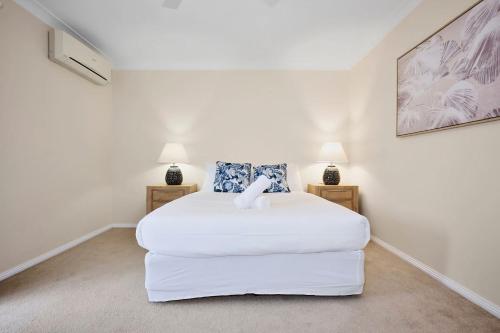 a white bed in a room with two lamps at Spacious 3BR Family Haven in Upper Ferntree Gully in Fern Tree Gully