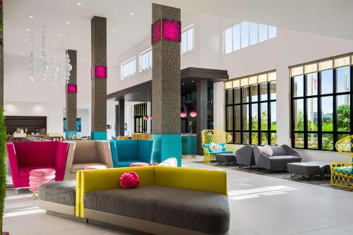 a lobby with colorful furniture in a building at Hilton Garden Inn Orlando I-4 Millenia Blvd Mall in Orlando