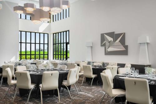 a dining room with tables and chairs and windows at Hilton Garden Inn Orlando I-4 Millenia Blvd Mall in Orlando