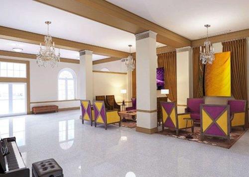 a lobby with purple and yellow chairs and tables at The Bolling Wilson Hotel in Wytheville