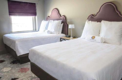 a hotel room with two beds and a window at The Bolling Wilson Hotel in Wytheville