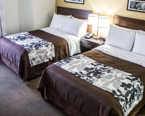 a hotel room with two beds and a desk at Sleep Inn Tinley Park I-80 near Amphitheatre-Convention Center in Tinley Park