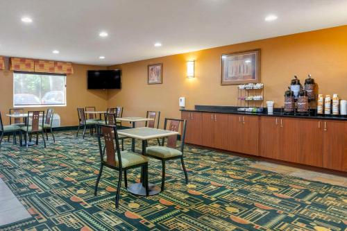 a hotel room with a bar and tables and chairs at Comfort Inn Traverse City in Traverse City