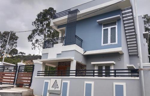 a blue and white house with a balcony at Dilmun Yercaud Villa in Yercaud