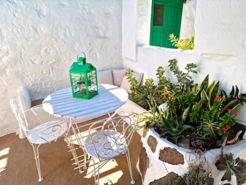 a table with chairs and a lantern on a patio at Historica Casa Juan in Mogán
