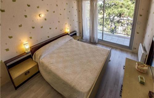 une chambre avec un grand lit et une grande fenêtre dans l'établissement Pet Friendly Apartment, à Saint-Georges-de-Didonne