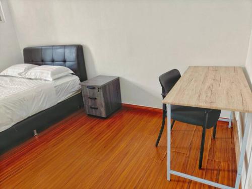 a bedroom with a bed and a desk with a chair at Setia Alam Convention Center Spacious House in Shah Alam