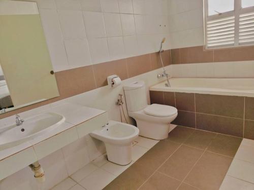 a bathroom with a sink and a toilet and a bath tub at Setia Alam Convention Center Spacious House in Shah Alam