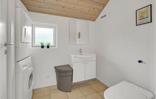 a white bathroom with a toilet and a sink at Holiday Home Vibelunden Rødby V in Kramnitse