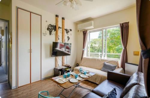 a living room with a couch and a table at Nuchigusui House in Motobu