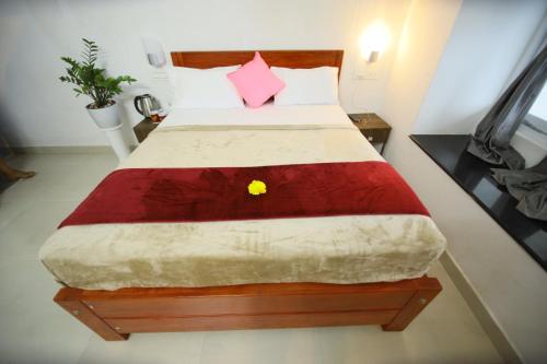 a bedroom with a large bed with a red blanket at Fairhaven Misty Hills in Vagamon