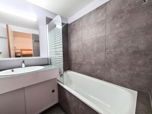 une salle de bain avec un lavabo, une baignoire et un miroir dans l'établissement Résidence Gemeaux - Appartement confortable · Centre station · Balcon MAE-7369, à Flaine