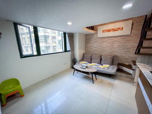 una sala de estar con un sofá y una mesa en 小牧湯泉民宿, en Jiaoxi
