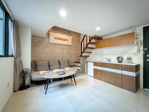 Una cocina con un sofá y una mesa en una habitación. en 小牧湯泉民宿, en Jiaoxi