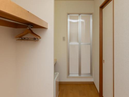 a hallway with a window in a white room at Tabist Hachi no Oyado Numadate Heights in Odate